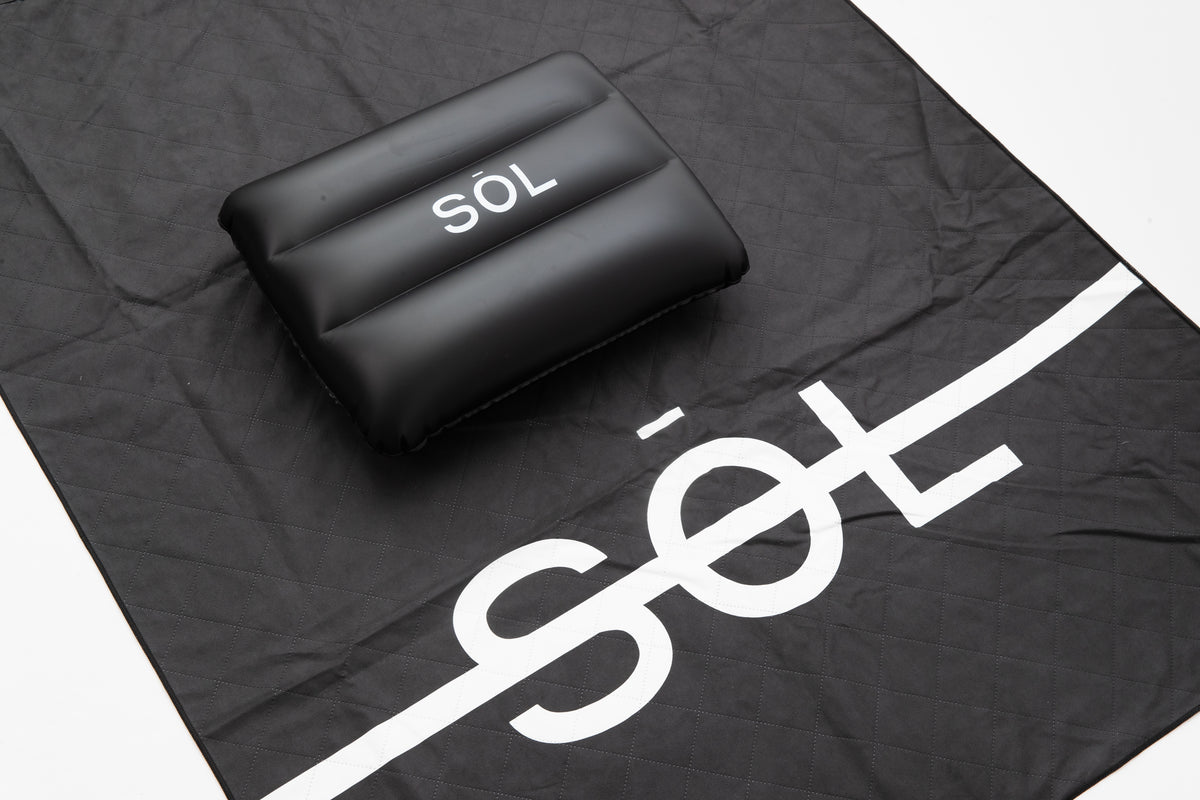 Close detail of the black SŌL Deluxe towel and inflatable pillow