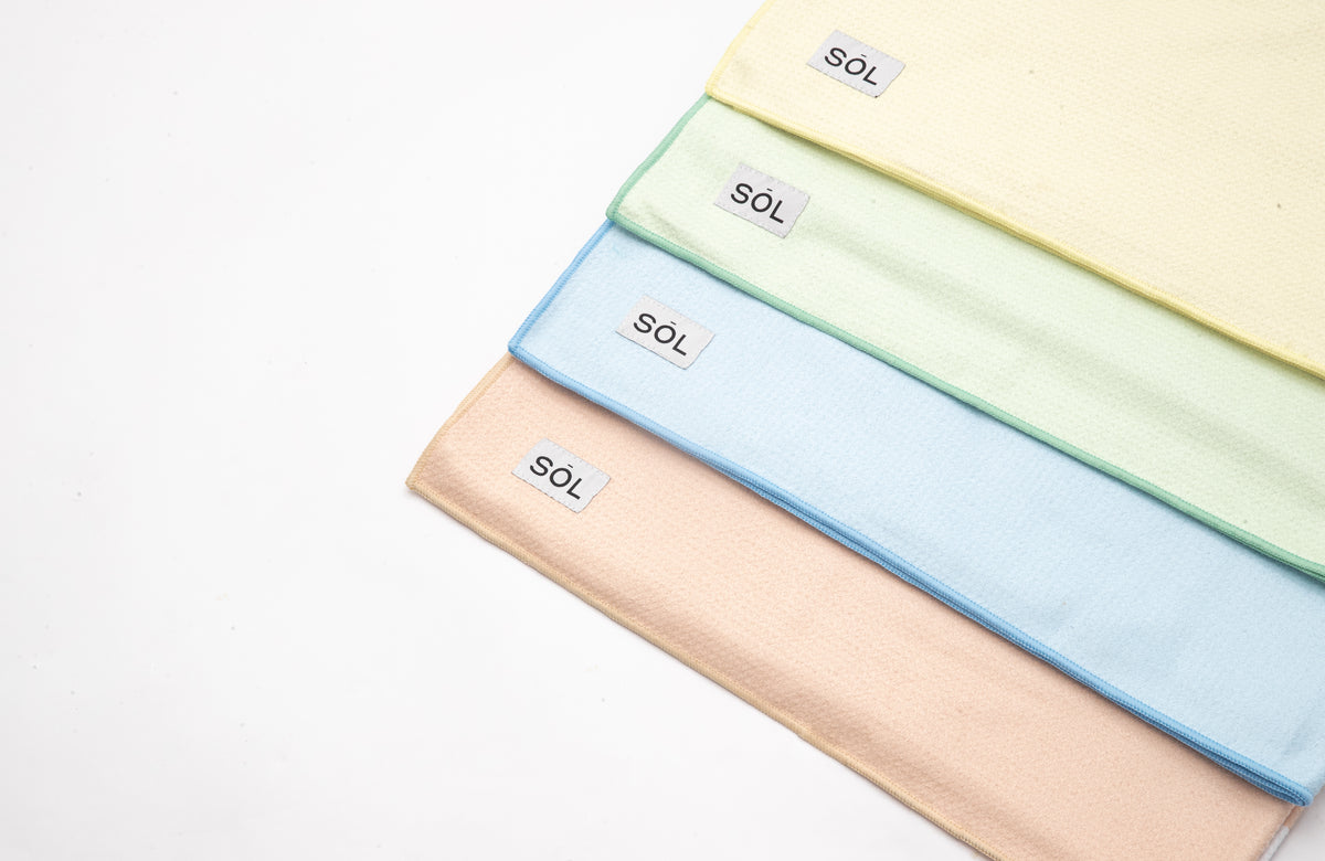 Four SŌL Essential towels stacked in Lemon, Lime, Ice and Peach